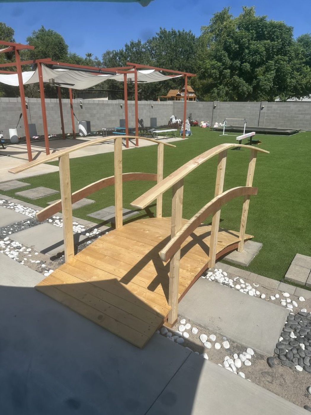 A custom wooden garden bridge with railings